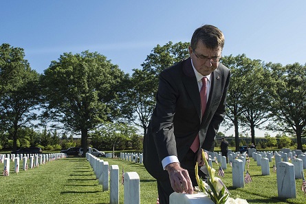 In May 2015, former Secretary of Defense Ashton Carter put a challenge coin on the headstone of a family friend. Photo: Department of Defense, Sean Hurt.