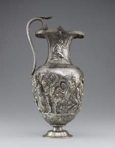 Pitcher with Scenes from the Trojan War of Achilles with Eight Greek Warriors. Weeping over the Body of Patroclus and Priam’s Embassy to Ransom Hector?s Body; Episodes from the Life of Achilles. Roman, 1-100 CE. Inscription: MERCVRIO AVGVSTO Q DOMITIVS TVTVS EX VOTO (To Augustan Mercury, Quintus Domitius Tutus in fulfillment of a vow). Find-spot: Berthouville, France. Silver and gold. H. 29.9 cm; W. 14.5; Circumference. 42 cm. Bibliothèque nationale de France, Paris: inv. 56.4. Photo: Tahnee Cracchiola © Getty-BnF.